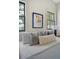Bedroom with a decorative painting on the wall, two windows, and pillows with neutral colors at 40 Pitt St, Charleston, SC 29401