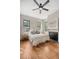 Stylish bedroom with hardwood floors, a decorative fireplace, neutral walls, and a ceiling fan at 40 Pitt St, Charleston, SC 29401