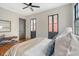 Bright bedroom with hardwood floors, a ceiling fan, windows, and a decorative fireplace at 40 Pitt St, Charleston, SC 29401