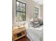 Bedroom with hardwood floors, a nightstand, two large windows, and white and blue decor accents at 40 Pitt St, Charleston, SC 29401