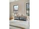 Bedroom with hardwood floors, a nightstand, two large windows, and white and blue decor accents at 40 Pitt St, Charleston, SC 29401