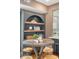 Cozy dining area with round table and barstools next to shelving and view to modern kitchen at 40 Pitt St, Charleston, SC 29401