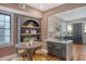 An inviting kitchen and dining area boasts an arched shelving unit and modern stools at the island at 40 Pitt St, Charleston, SC 29401