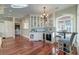 Elegant bar area with glass-front cabinets, a wine cooler, and a cozy seating area near the windows at 4009 Ballovista Rd, Johns Island, SC 29455