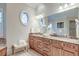 Bright bathroom features double vanity with granite countertop and an oval window bringing in natural light at 4009 Ballovista Rd, Johns Island, SC 29455