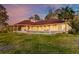 Beautiful home exterior featuring a long, covered patio and expansive lawn at sunset at 4009 Ballovista Rd, Johns Island, SC 29455