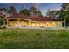 Expansive backyard view of elegant single-story home with stunning pool, lush lawn and covered porch at 4009 Ballovista Rd, Johns Island, SC 29455