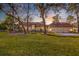 Manicured lawn showcases a stately home with 3-car garage, mature trees, and scenic lighting at 4009 Ballovista Rd, Johns Island, SC 29455