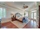 Spacious main bedroom with a tray ceiling, ceiling fan, hardwood floors, and plantation shutters for natural light and privacy at 4009 Ballovista Rd, Johns Island, SC 29455