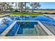 Relaxing inground pool with spill-over spa, reflecting the lush green surroundings and blue sky at 4009 Ballovista Rd, Johns Island, SC 29455
