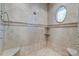 Inside the shower stall showcasing tiled walls, pebble floor, shelving niche, and a charming oval window at 4009 Ballovista Rd, Johns Island, SC 29455