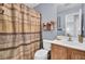 Well-lit bathroom featuring a vanity with wood cabinets, a white toilet, and a patterned shower curtain at 402 Pine Bluff Dr, Summerville, SC 29483