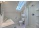 Bright bathroom with a skylight, white fixtures, and a shower at 4462 Francis Yonge Way, Hollywood, SC 29449