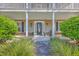 Charming front porch with white columns, decorative fish, and manicured landscaping at 4462 Francis Yonge Way, Hollywood, SC 29449