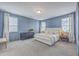 Spacious primary bedroom featuring elegant blue walls, plush carpet, and lots of natural light at 667 Black Pine Rd, Moncks Corner, SC 29461