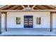 Inviting front porch with exposed wood beams, a modern front door, and views of the surrounding landscape at 709 Oakridge View Trl, Ridgeville, SC 29472