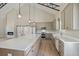 Bright kitchen with gray cabinets, large island, stainless appliances, and high ceiling with modern pendant lights at 709 Oakridge View Trl, Ridgeville, SC 29472