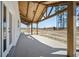 Covered porch with exposed wood beams, ceiling fan, and view of surrounding trees at 709 Oakridge View Trl, Ridgeville, SC 29472