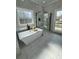 Bright, modern bathroom with a soaking tub, glass-enclosed shower, and abundant natural light at 85 Prestwick Pl, Walterboro, SC 29488