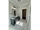Elegant bathroom showcasing a modern vanity, decorative wallpaper, and access to a walk-in closet at 85 Prestwick Pl, Walterboro, SC 29488