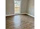 Bright bedroom featuring wood-look floors, white trim, and a sun-filled window providing ample natural light at 85 Prestwick Pl, Walterboro, SC 29488