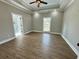 Spacious bedroom with a tray ceiling, wood floors, and natural light from a window at 85 Prestwick Pl, Walterboro, SC 29488