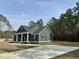 Inviting home with dark siding, white trim, black shutters, a welcoming front porch, and a long driveway at 85 Prestwick Pl, Walterboro, SC 29488