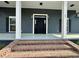 Close-up of a home's front door showing brick steps, white columns, dark siding, and sidelights at 85 Prestwick Pl, Walterboro, SC 29488