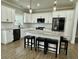 Well-lit kitchen with white cabinets, stainless steel appliances, a large island, and breakfast bar seating at 85 Prestwick Pl, Walterboro, SC 29488
