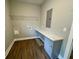 Functional laundry room with countertop, cabinet, shelving, and wood-look floors at 85 Prestwick Pl, Walterboro, SC 29488