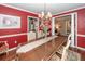 Spacious dining room featuring red walls, an elegant chandelier, and a view into the living room at 874 Law Ln, Mount Pleasant, SC 29464