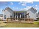 A spacious backyard view showcases a wooden deck and screened-in porch, perfect for outdoor relaxation and entertaining at 9394 Harroway Rd, Summerville, SC 29485