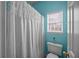 Bathroom with white shower curtain, toilet, and a window at 9394 Harroway Rd, Summerville, SC 29485
