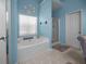 Bathroom featuring a soaking tub, a separate shower, and bright blue walls at 9394 Harroway Rd, Summerville, SC 29485
