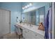 Bright bathroom with a white vanity, a large mirror, and a comfortable chair at 9394 Harroway Rd, Summerville, SC 29485