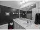 Stylish black and white bathroom with a modern vanity, framed mirror, and polka-dot accents, combining elegance and playfulness at 9394 Harroway Rd, Summerville, SC 29485