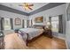 Bedroom with hardwood floors, gray accent ceiling and natural light from multiple windows at 9394 Harroway Rd, Summerville, SC 29485