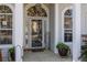 Inviting front porch with arched windows, columns, potted plants, and stylish decor at 9394 Harroway Rd, Summerville, SC 29485