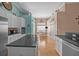 Bright kitchen showcases hardwood floors, granite countertops and white cabinetry leading to dining area at 9394 Harroway Rd, Summerville, SC 29485