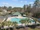 Aerial view of a pool with palm trees and a green roofed building surrounded by trees at 9394 Harroway Rd, Summerville, SC 29485