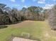Aerial view of a green soccer field surrounded by trees and a black fence at 9394 Harroway Rd, Summerville, SC 29485