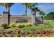 Entrance to The Club at Dunes West, with brick signage, lush landscaping, and palm trees at 1032 Black Rush Cir, Mount Pleasant, SC 29466