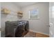 Functional laundry room featuring a front-load washer and dryer and wood shelving above at 1032 Black Rush Cir, Mount Pleasant, SC 29466
