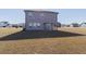 Rear view of a gray two-story home featuring a covered patio and a spacious backyard at 112 Edisto Crossing Ct, Ridgeville, SC 29472