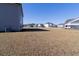 Spacious backyard showing ample grass, neighboring houses, and a compact truck, great for outdoor activities at 112 Edisto Crossing Ct, Ridgeville, SC 29472