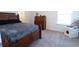 Cozy bedroom featuring carpeted floors, a classic wooden bed frame, and natural lighting at 112 Edisto Crossing Ct, Ridgeville, SC 29472