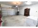 Spacious garage featuring a roll-up door, concrete floor, storage shelving, and a deep freezer at 112 Edisto Crossing Ct, Ridgeville, SC 29472