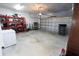 Spacious garage with a roll-up door, concrete floor, ample storage, and an adjacent deep freezer at 112 Edisto Crossing Ct, Ridgeville, SC 29472