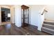 Elegant hallway featuring hardwood floors, a display cabinet, and staircase leading to the upper level at 112 Edisto Crossing Ct, Ridgeville, SC 29472