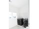 A modern laundry room with front loading washer and dryer and a shelf for storage at 112 Edisto Crossing Ct, Ridgeville, SC 29472